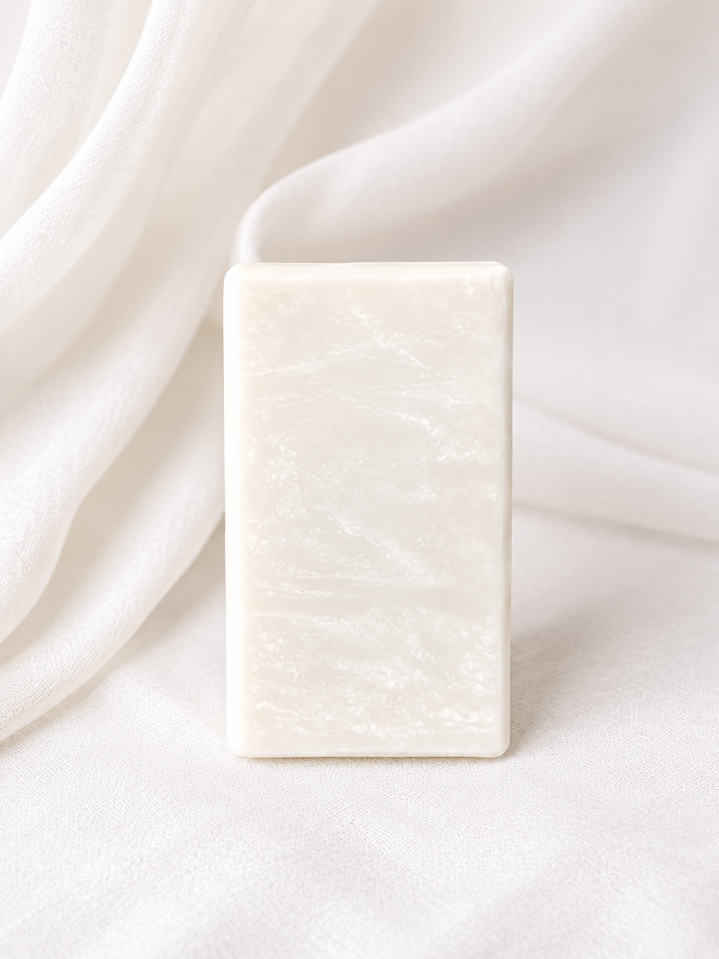 Natural handmade soap bar with a creamy white marbled design, crafted with plant-based ingredients and photographed on a soft neutral fabric backdrop for a clean, minimalist skincare aesthetic.