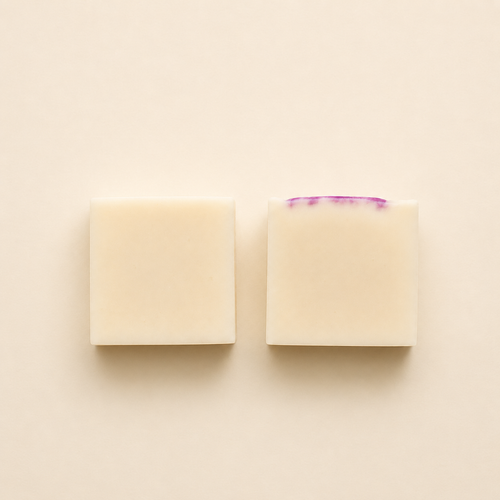 Handmade artisan soap bars with a creamy ivory finish, displayed in a minimalist flat lay composition on a soft neutral background.