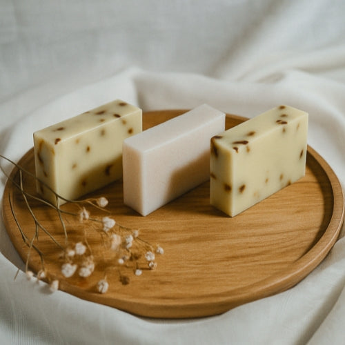 Natural cold-process soaps infused with herbs and botanicals, photographed in a clean, minimal layout.